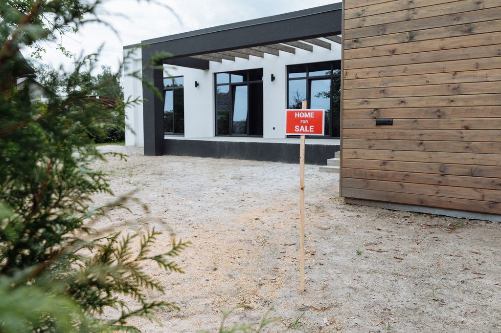 Modern house exterior with a 'Home for sale' sign